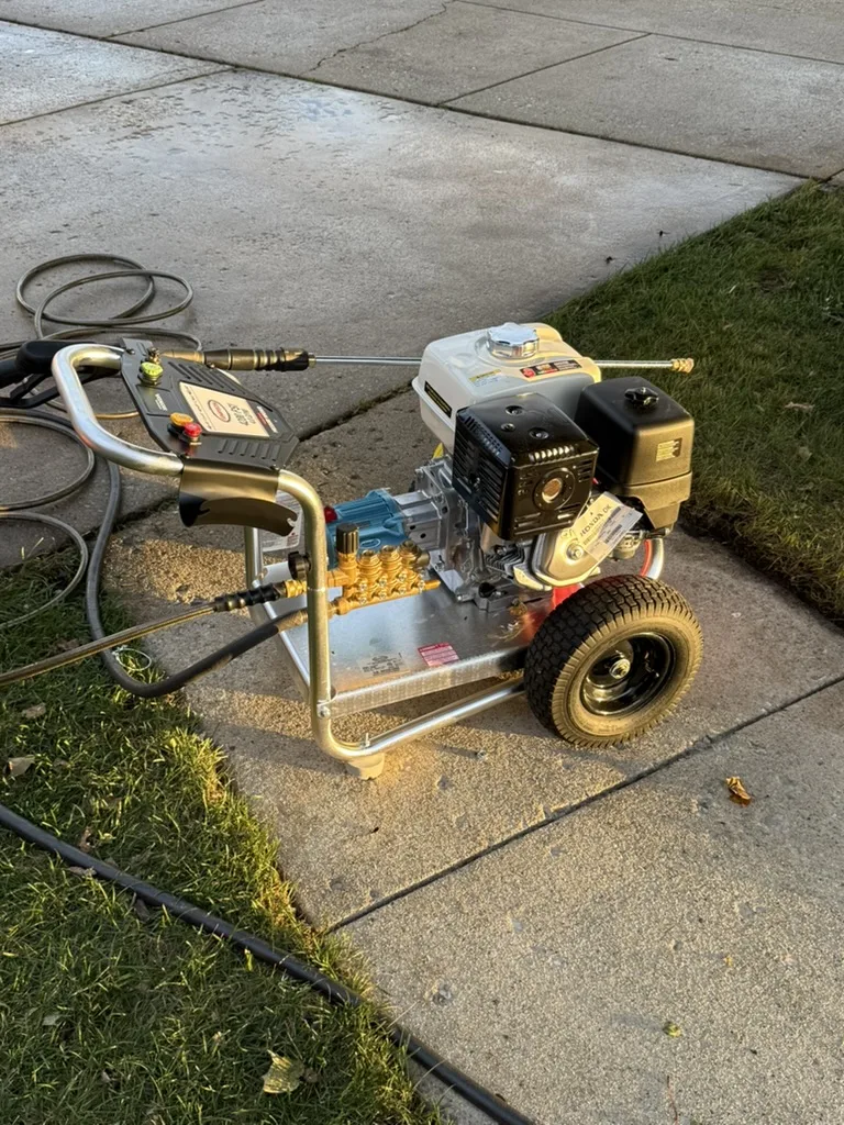 Minaki Wash pressure washer on a sidewalk at sunset